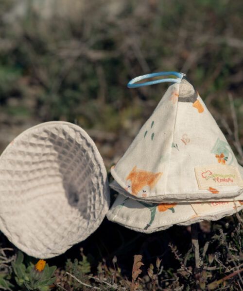 Conos de pipí reutilizables para bebé hechos a mano, con tejido estampado infantil y rizo absorbente, sobre fondo natural.