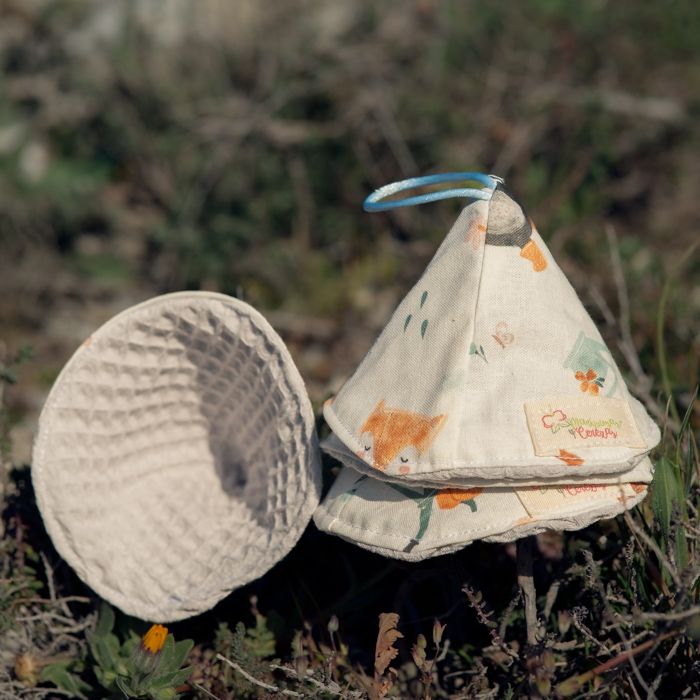 Conos de pipí reutilizables para bebé hechos a mano, con tejido estampado infantil y rizo absorbente, sobre fondo natural.