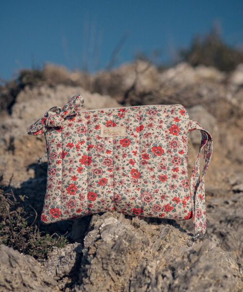 Neceser de mano floral en tonos rojos con lazo decorativo