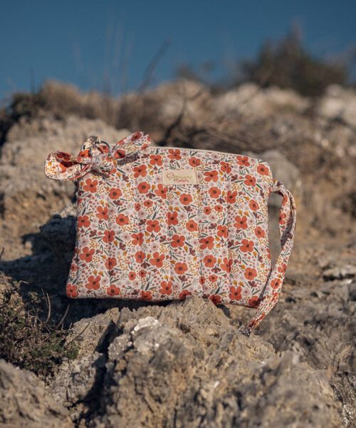 Neceser de mano floral en tonos naranja con lazo decorativo