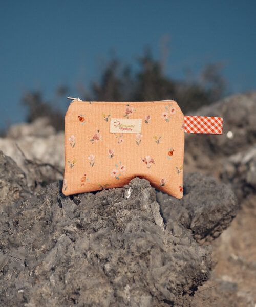 Monedero de tela en tono melocotón con estampado floral y detalle vichy