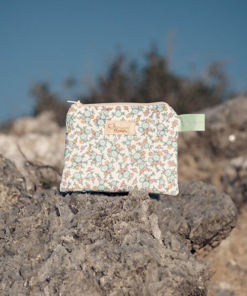 Monedero de tela floral en tonos suaves sobre fondo claro