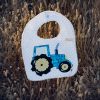 Babero infantil artesanal con aplicación de un tractor.
