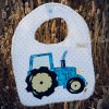 Babero infantil artesanal con aplicación de un tractor.
