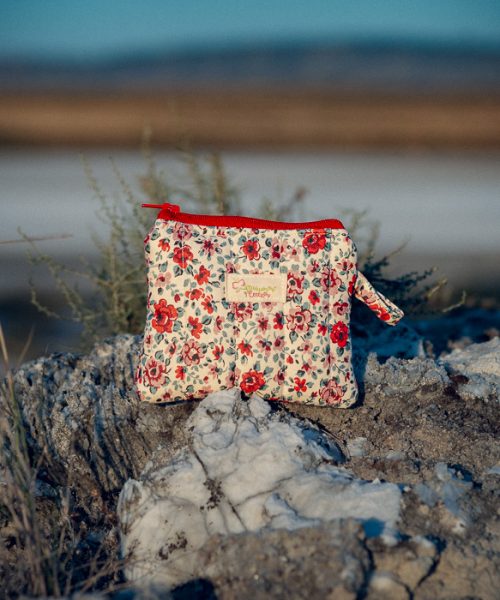 Monedero de tela acolchado con estampado de flores rojas confeccionado artesanalmente.