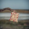 Monedero de tela acolchado con estampado de flores rojas confeccionado artesanalmente.
