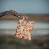 Monedero de tela acolchado con estampado de flores rojas confeccionado artesanalmente.