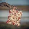 Monedero de tela acolchado con estampado de flores rojas confeccionado artesanalmente.