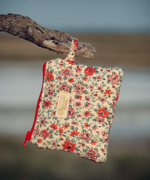 Monedero de tela acolchado con estampado de flores rojas confeccionado artesanalmente.