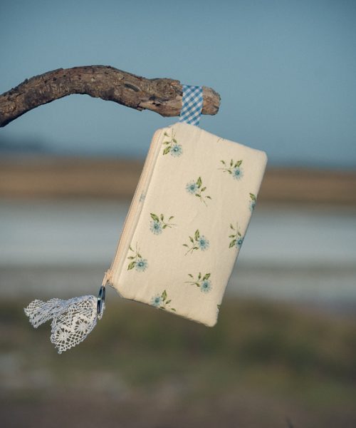 Estuche de tela acolchado con estampado de flores azules confeccionado artesanalmente.