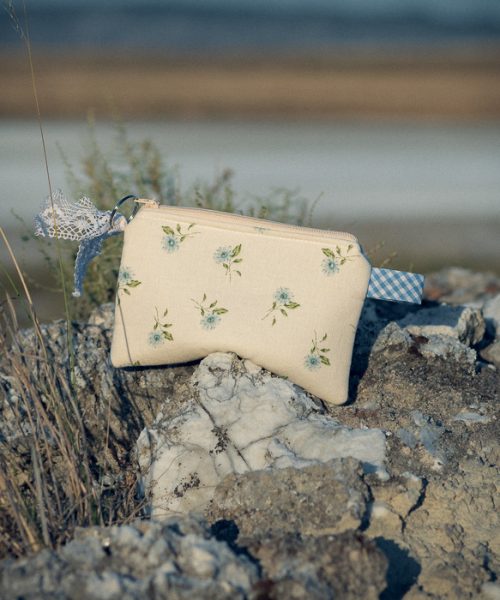 Estuche de tela acolchado con estampado de flores azules confeccionado artesanalmente.