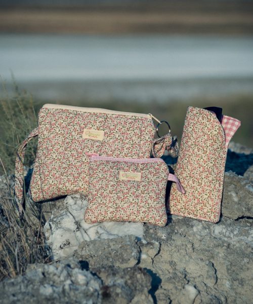 Set de accesorios de tela formado por neceser, monedero y funda para gafas con estampado de flores románticas.