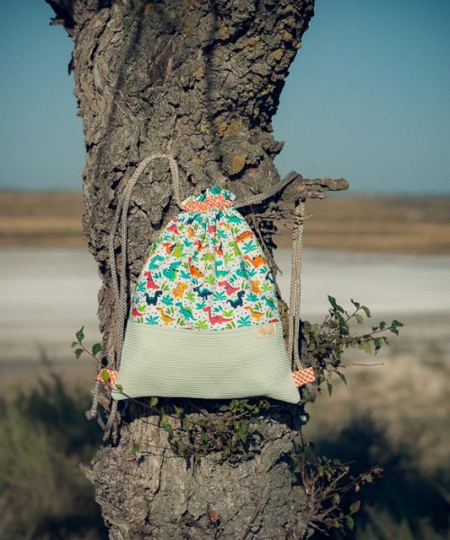 Mochila infantil pequeña de tela con estampado de dinosaurios hecha a mano.