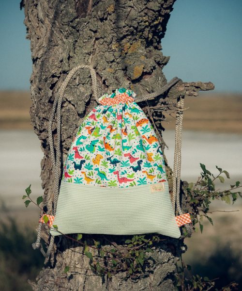Mochila infantil pequeña de tela con estampado de dinosaurios hecha a mano.