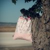Mochila infantil pequeña de tela con estampado de lazos sobre fondo rosa hecha a mano.