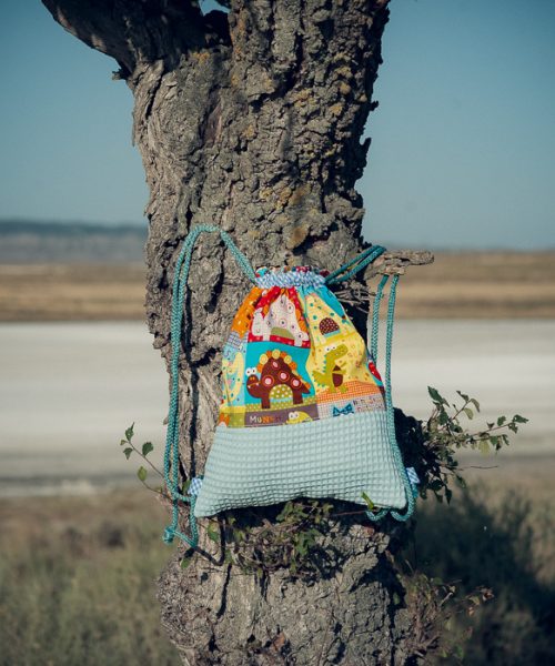 Mochila infantil pequeña de tela con estampado de dinosaurios de colores hecha a mano.
