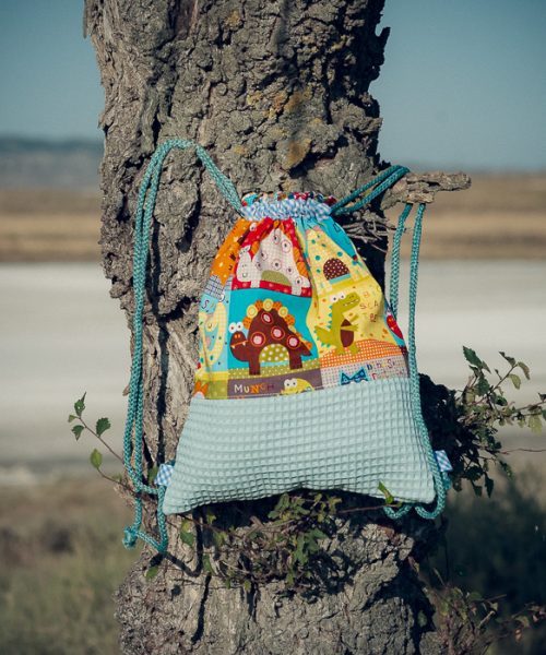Mochila infantil pequeña de tela con estampado de dinosaurios de colores hecha a mano.