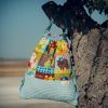 Mochila infantil pequeña de tela con estampado de dinosaurios de colores hecha a mano.