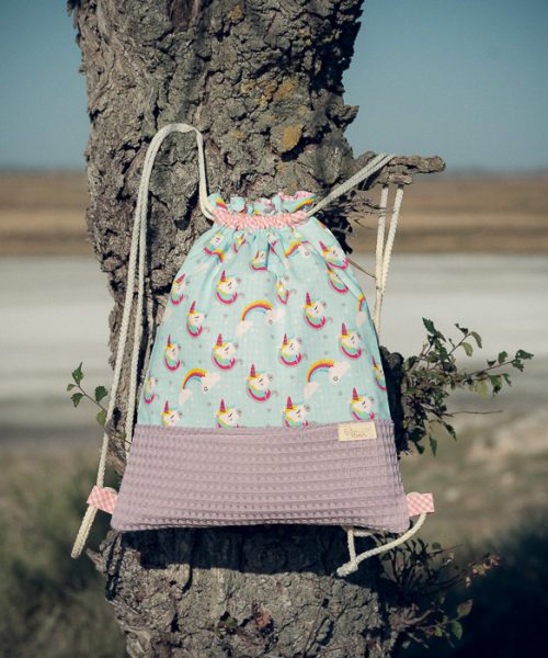 Mochila infantil grande de tela con estampado de unicornios sobre fondo azul hecha a mano.