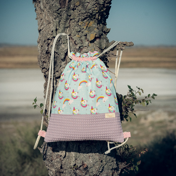 Mochila infantil grande de tela con estampado de unicornios sobre fondo azul hecha a mano.