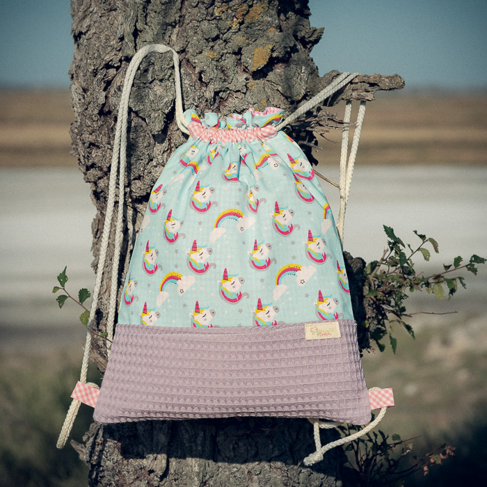 Mochila infantil grande de tela con estampado de unicornios sobre fondo azul hecha a mano.