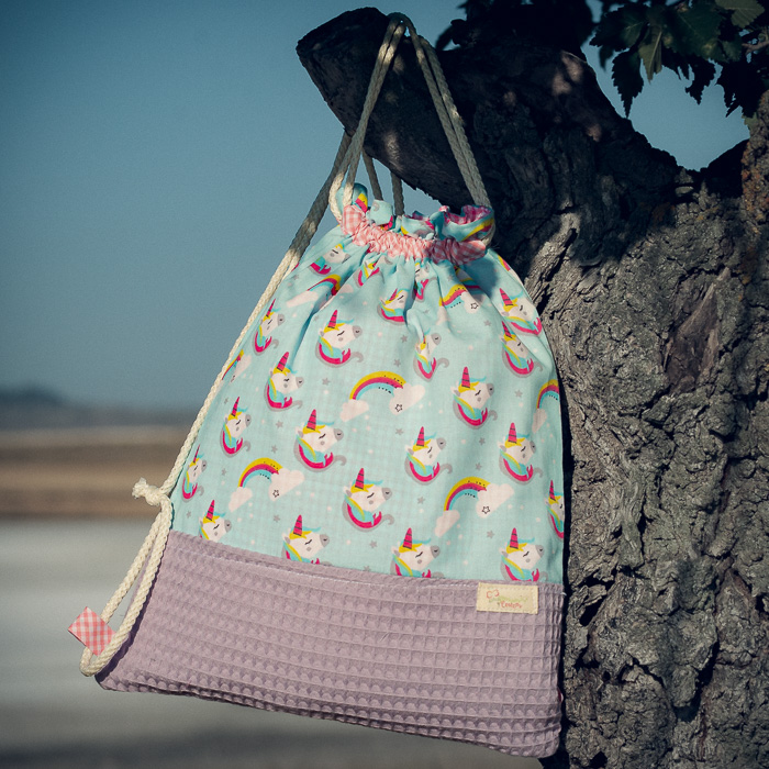 Mochila infantil grande de tela con estampado de unicornios sobre fondo azul hecha a mano.