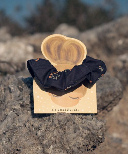 Coletero de tela oscuro con estampado floral delicado