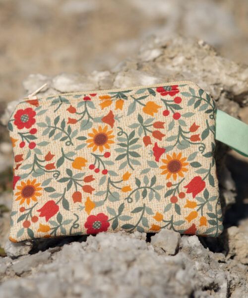 Monedero hecho a mano con estampado floral en tonos cálidos sobre fondo claro